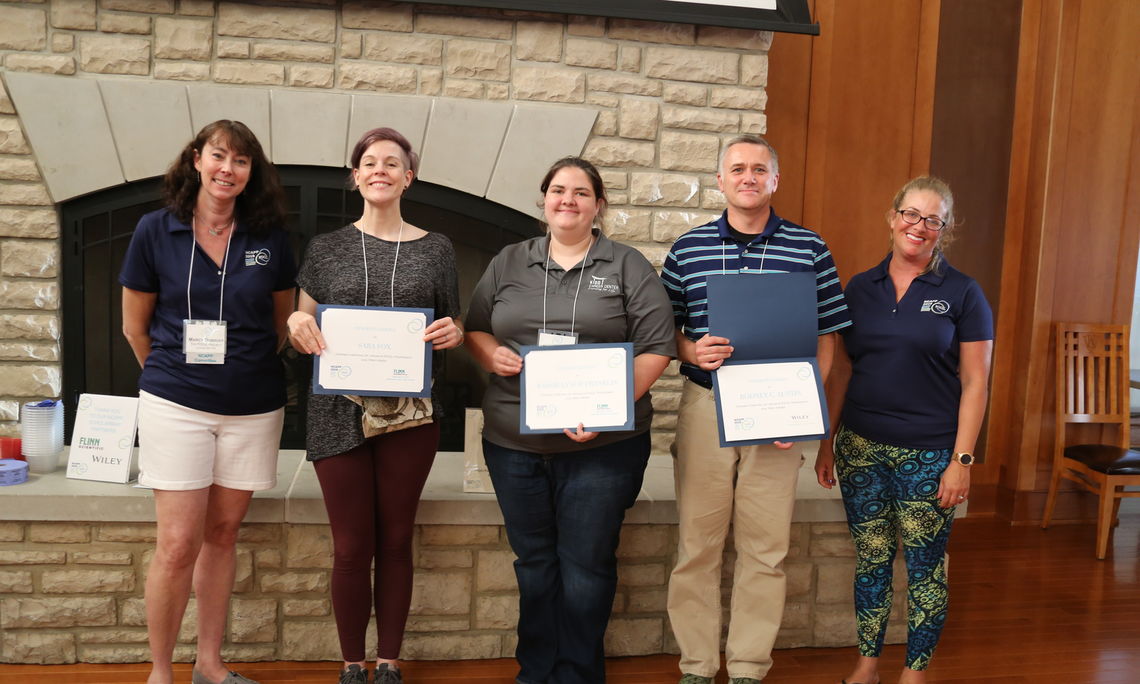 Marcy Dubroff (left) of The POGIL Project, poses with scholarship winners (Sara Fox, Kassie Lynch, Rodney Austin) and presenter Ashley Hill (right).